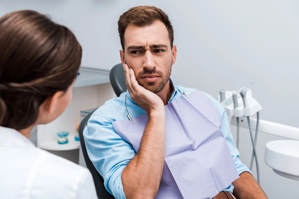 man at the dentist having tooth pain